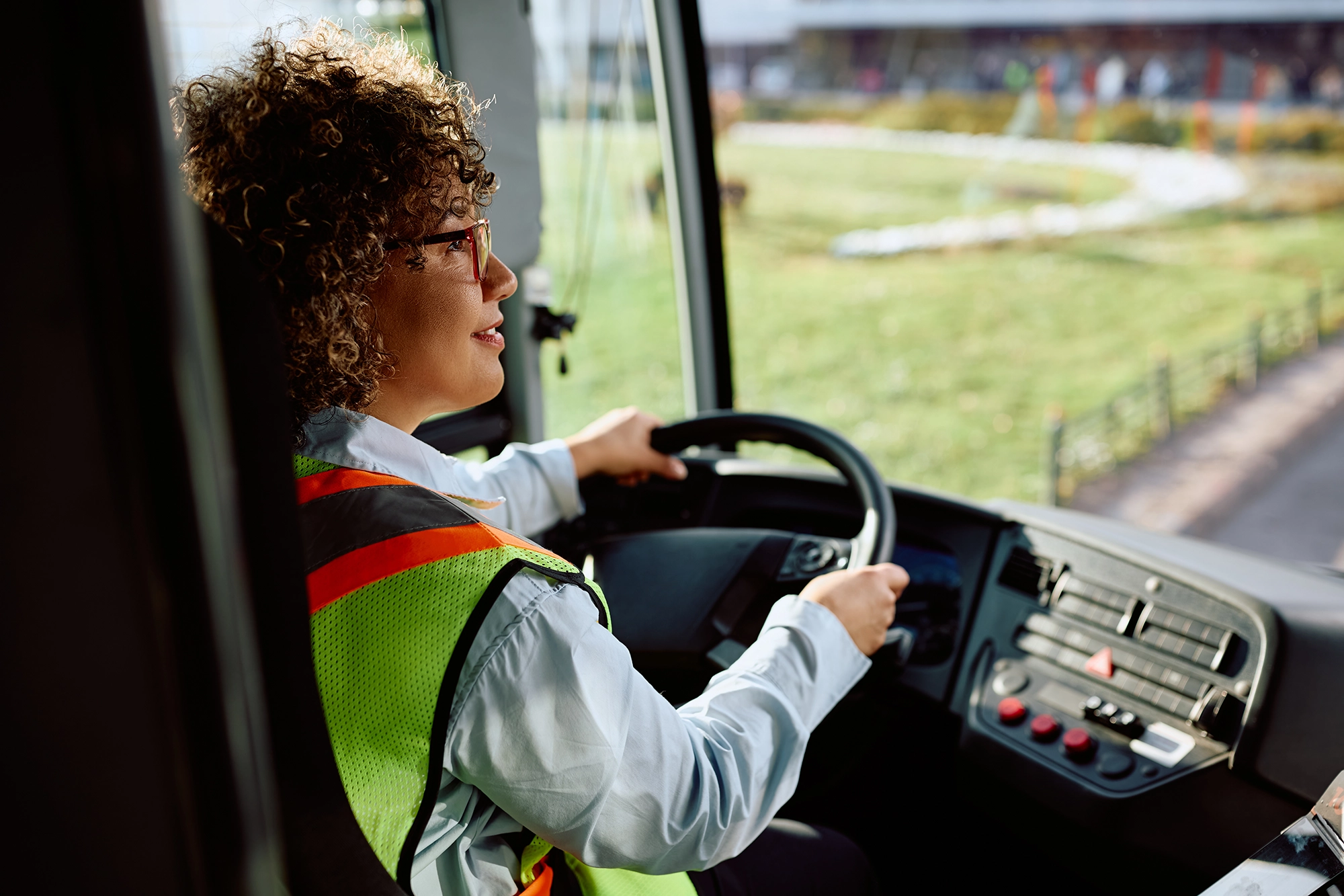A CDL / Commercial bus driver driving her bus.