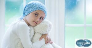 A small girl with leukemia, clutching her stuff toy