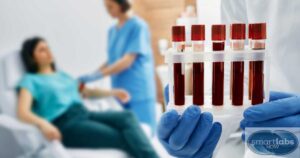 An oncology nurse administering chemo to a patient while a lab technician holds her blood samples.