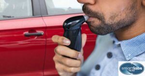 A male driver using a breathalyzer.